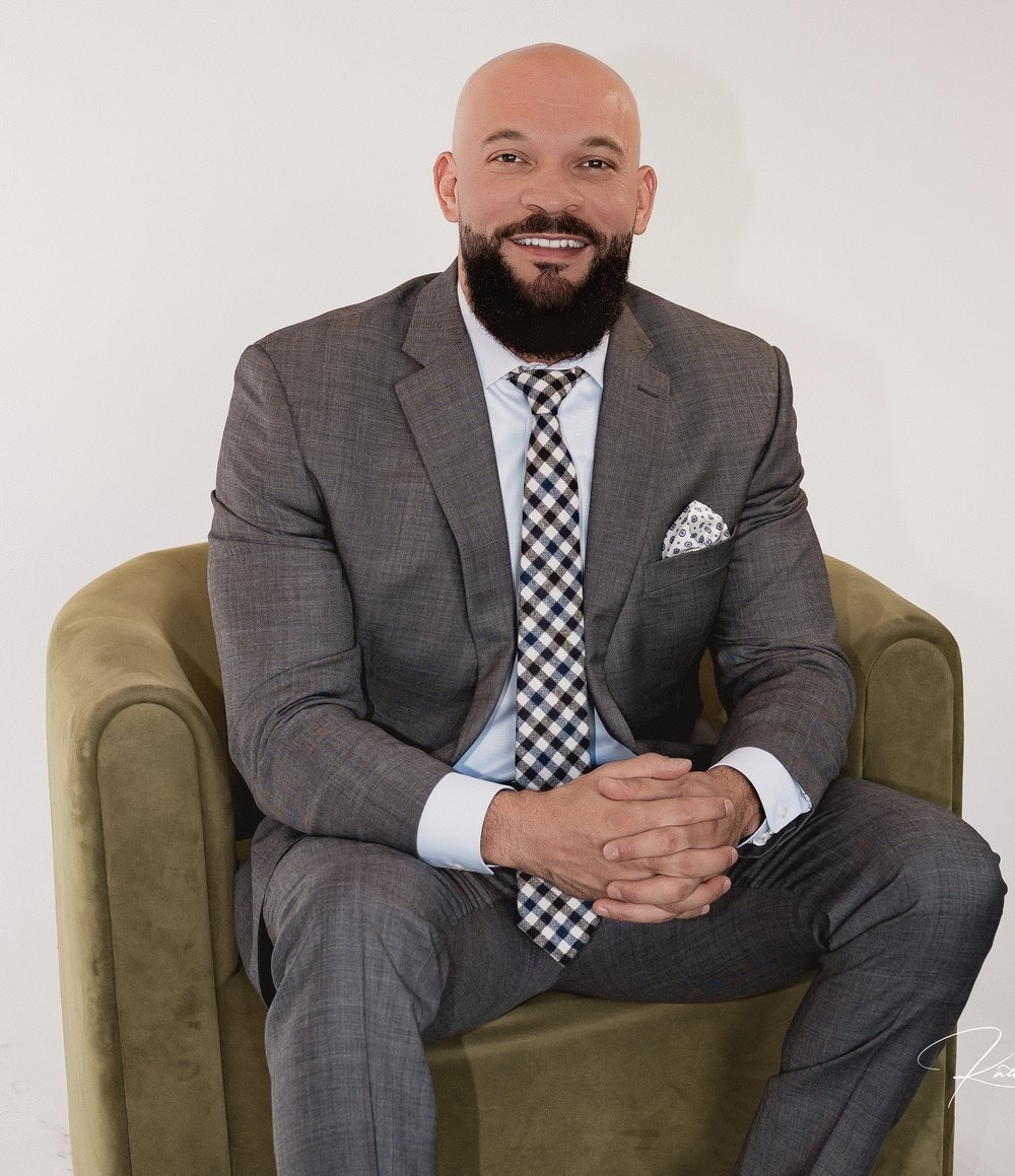 Terry McDonald smiling while seated in a green armchair